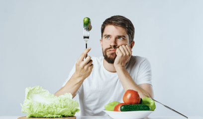 Man with vegetables gaffel med agurk