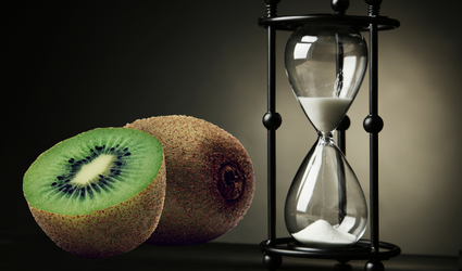 To kiwi, en delt i to, liggende ved siden av et timeglass med sand som faller gjennom det, og gjengir at noen gunstige forbindelser i mat har en tidsbegrenset platåeffekt.